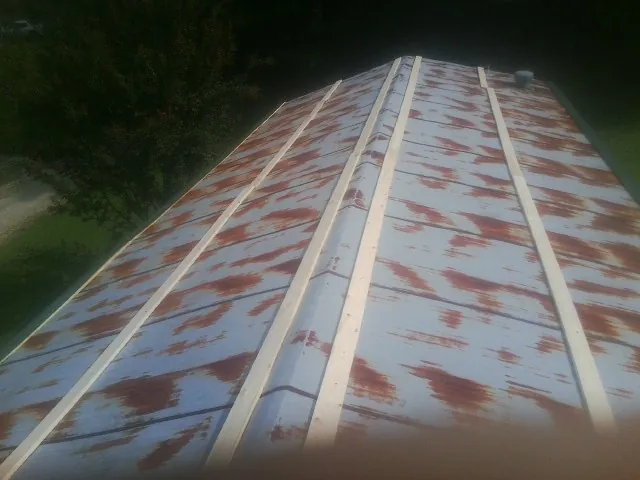Rusted metal roof panels with new wood purlins before replacement — Storm Damage Roof Repair in Toney by Roofing Brothers