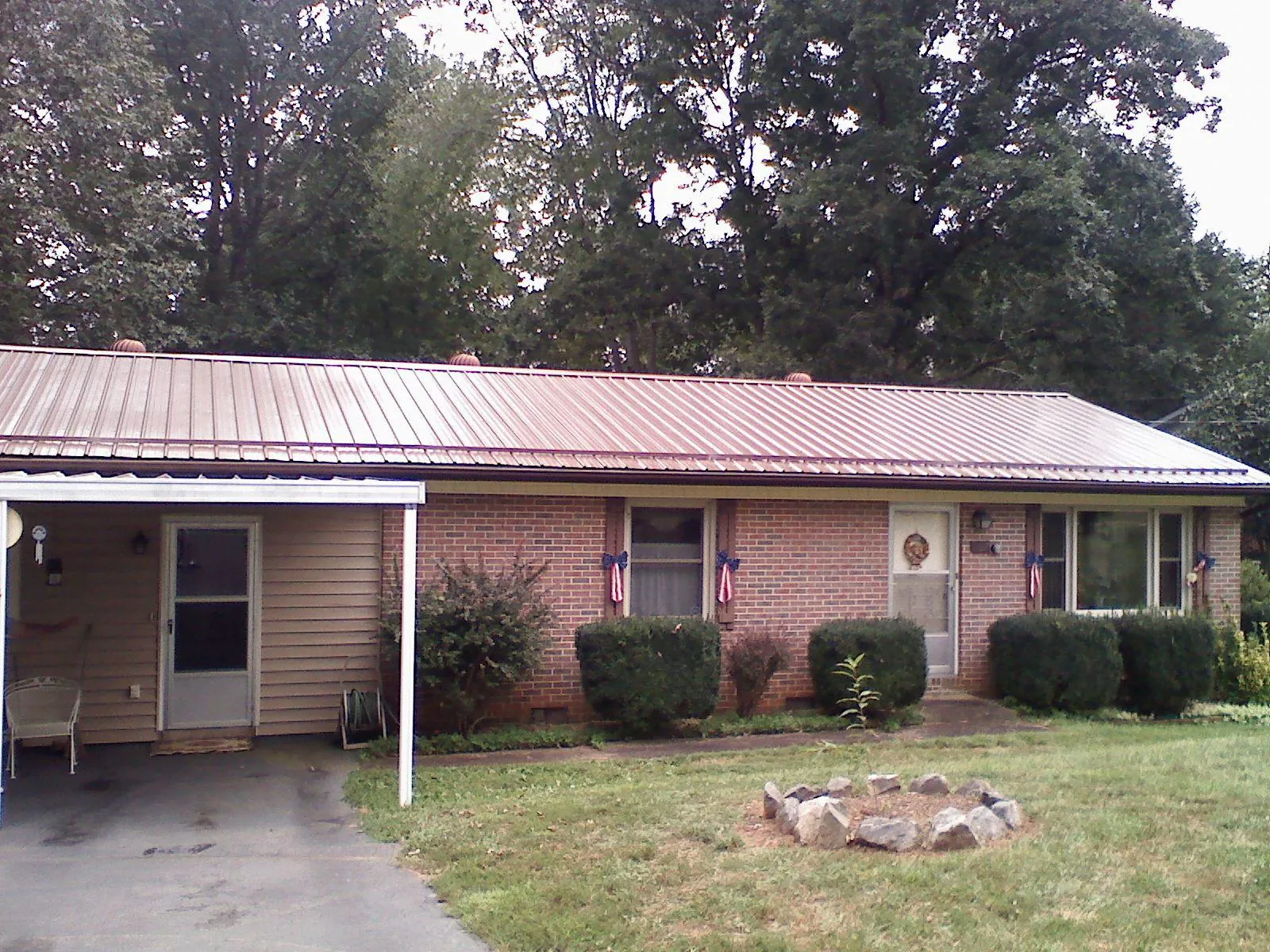Bronze metal roof and carport on a brick ranch home — Roof Repair work by our crew in Toney